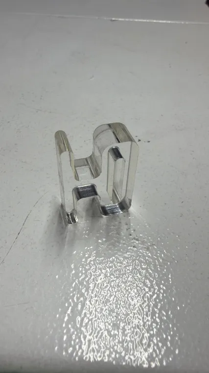 Small transparent machined component on a work surface