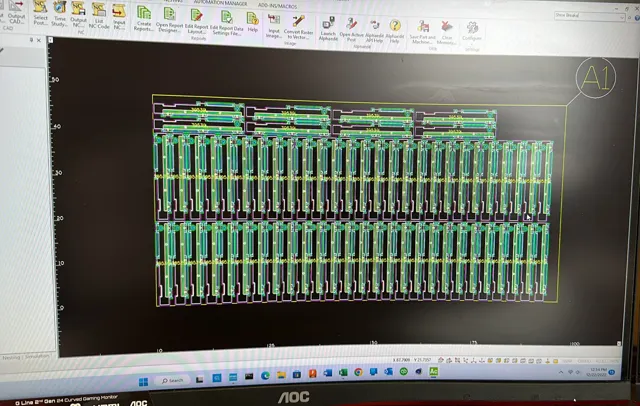 Alphacam toolpaths and nested parts displayed on a monitor