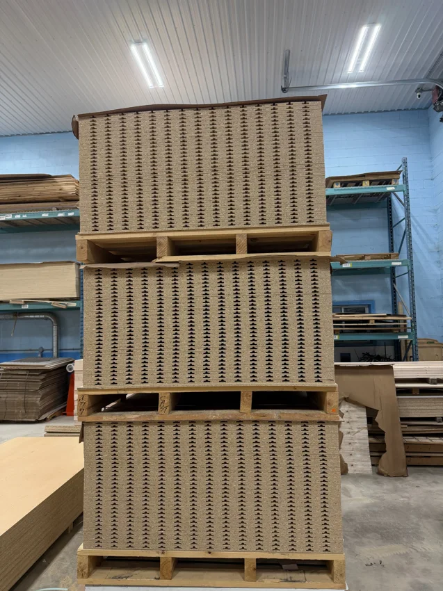 Stacks of CNC-routed slatwall panels on pallets at Cedar Hedge Millworks