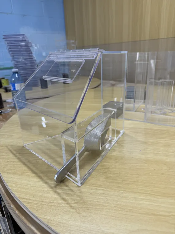 Clear acrylic boxes assembled on a shop workbench
