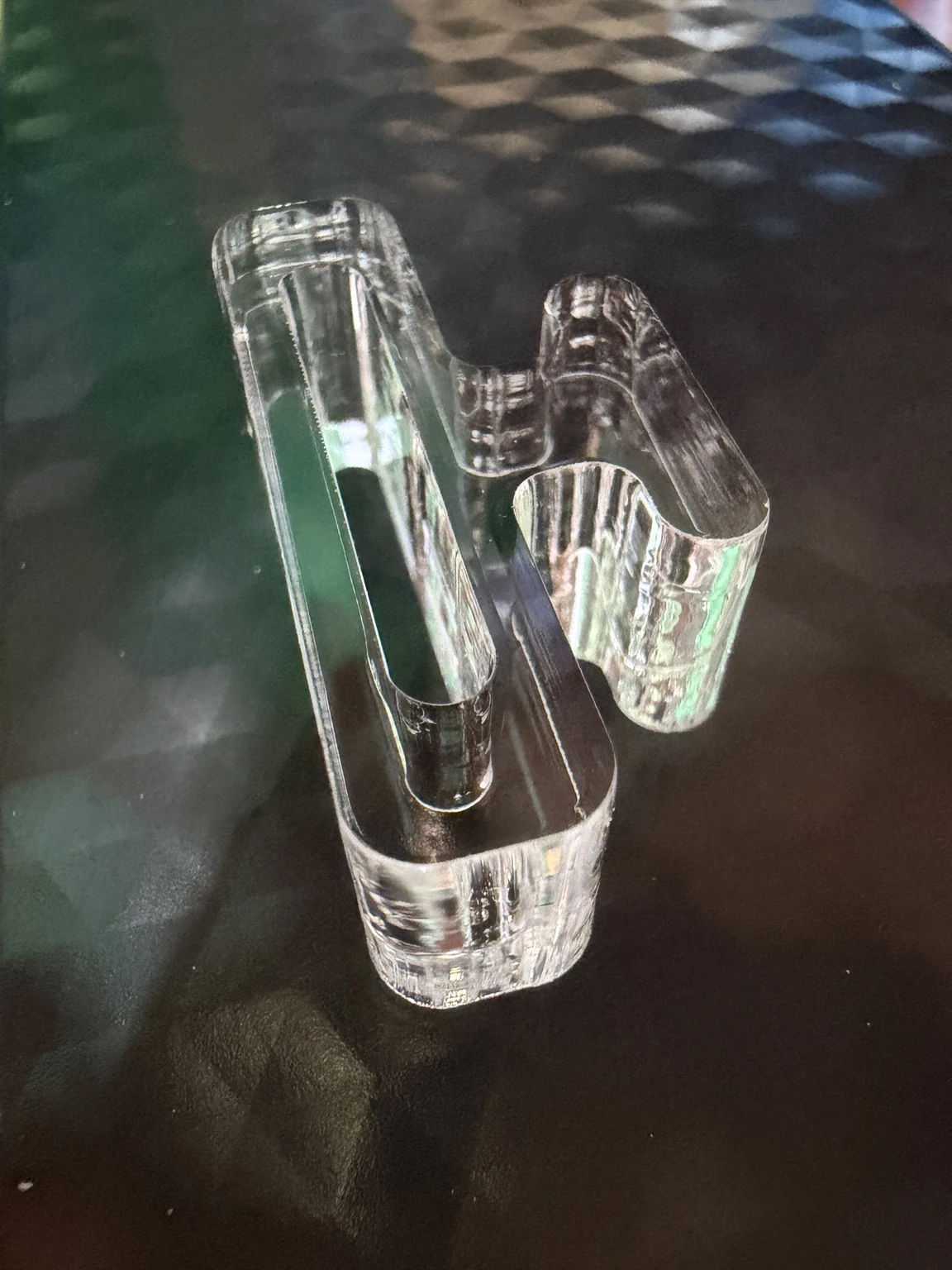 Laser-cut clear acrylic part with curved profiles and internal cutouts