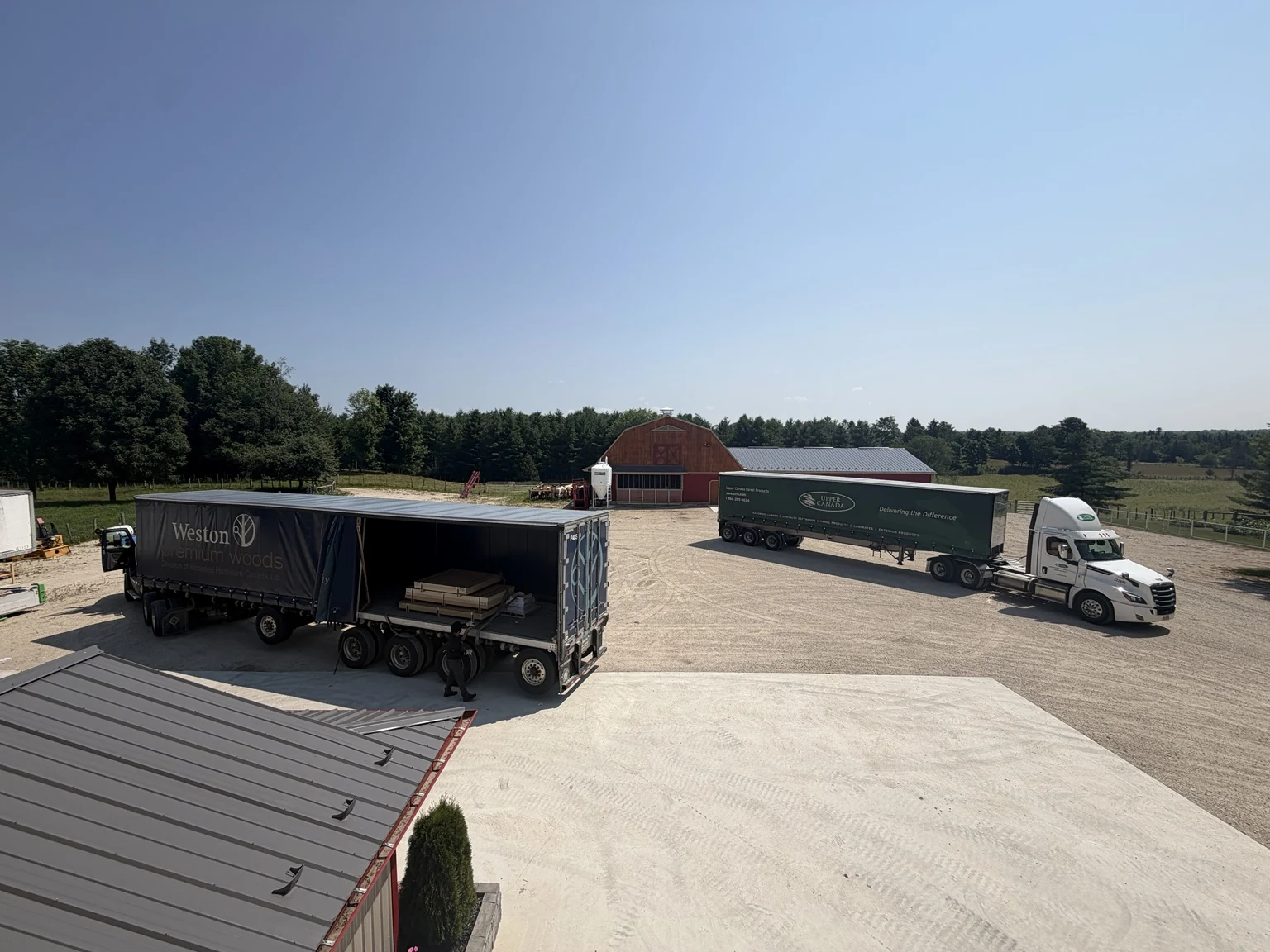 Delivery trucks in the Cedar Hedge Millworks yard, including an open curtain-side trailer