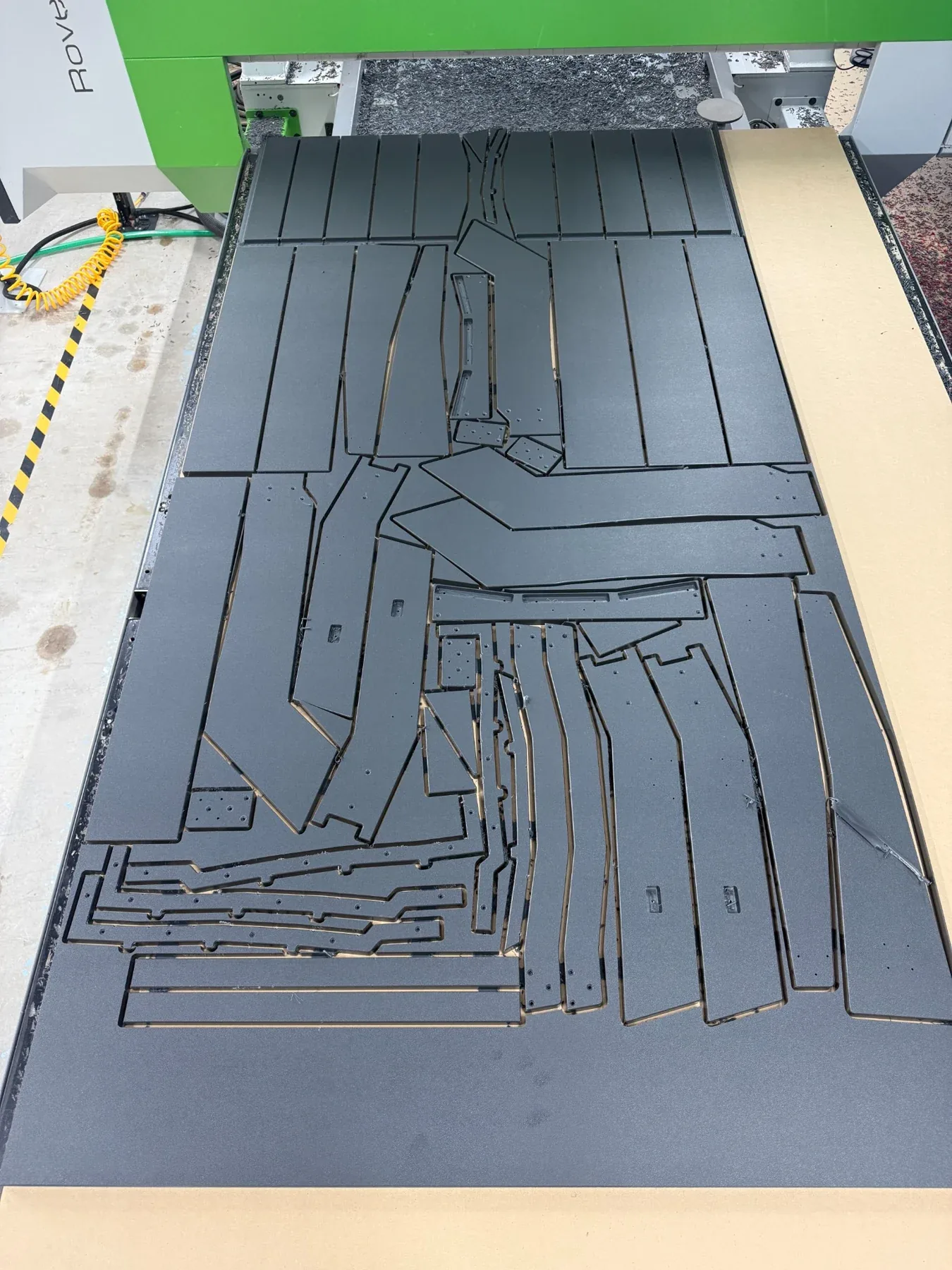 Nested plastic components — Furniture parts cut in a tight sheet layout to make efficient use of material.